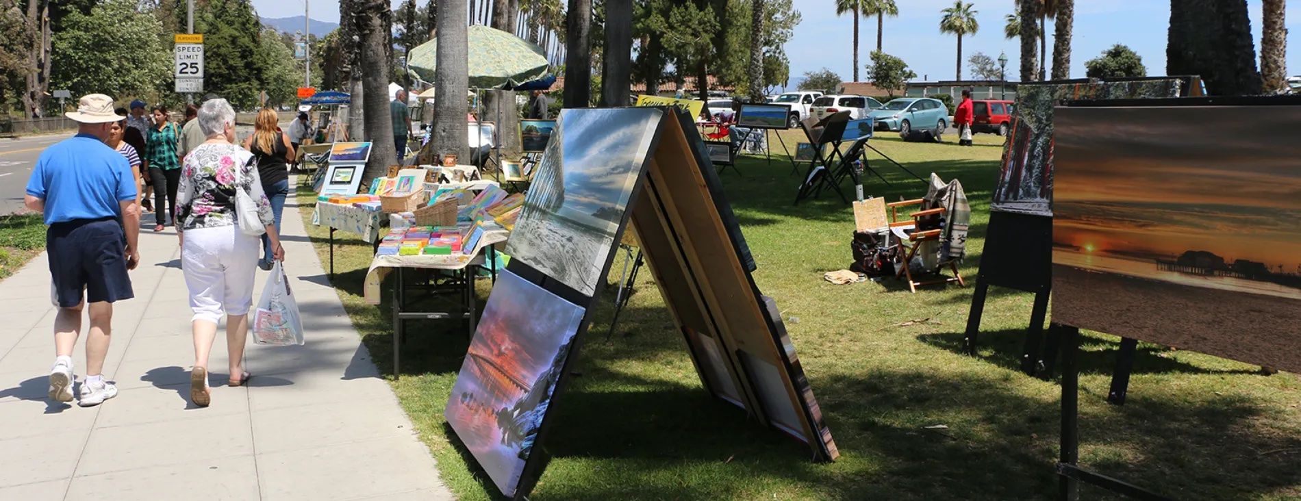 People walking down the sidewalk at the Santa Barbara Sunday art fair